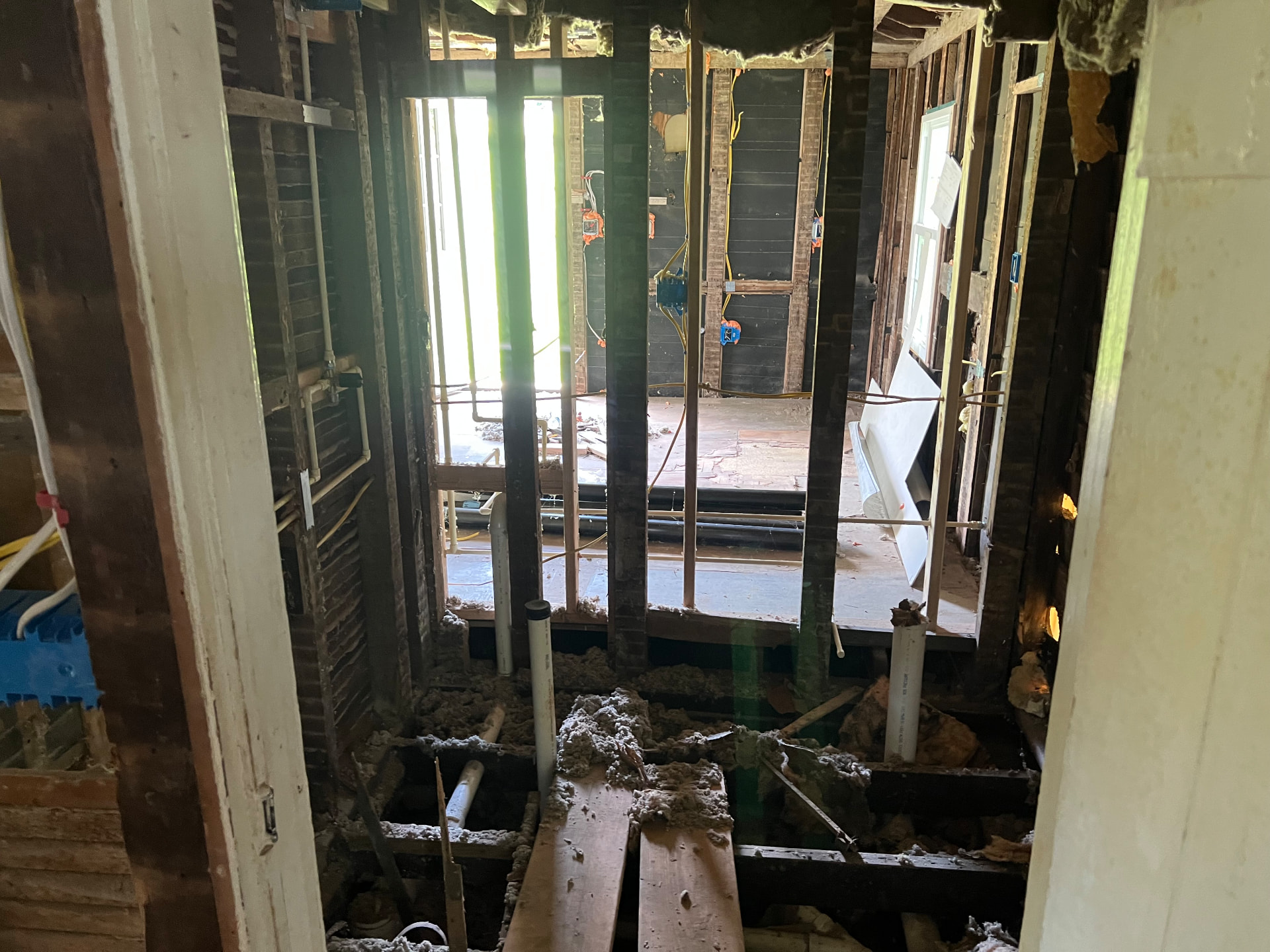 Floors opened to the joists as new plumbing and wiring are run through the rear of the house