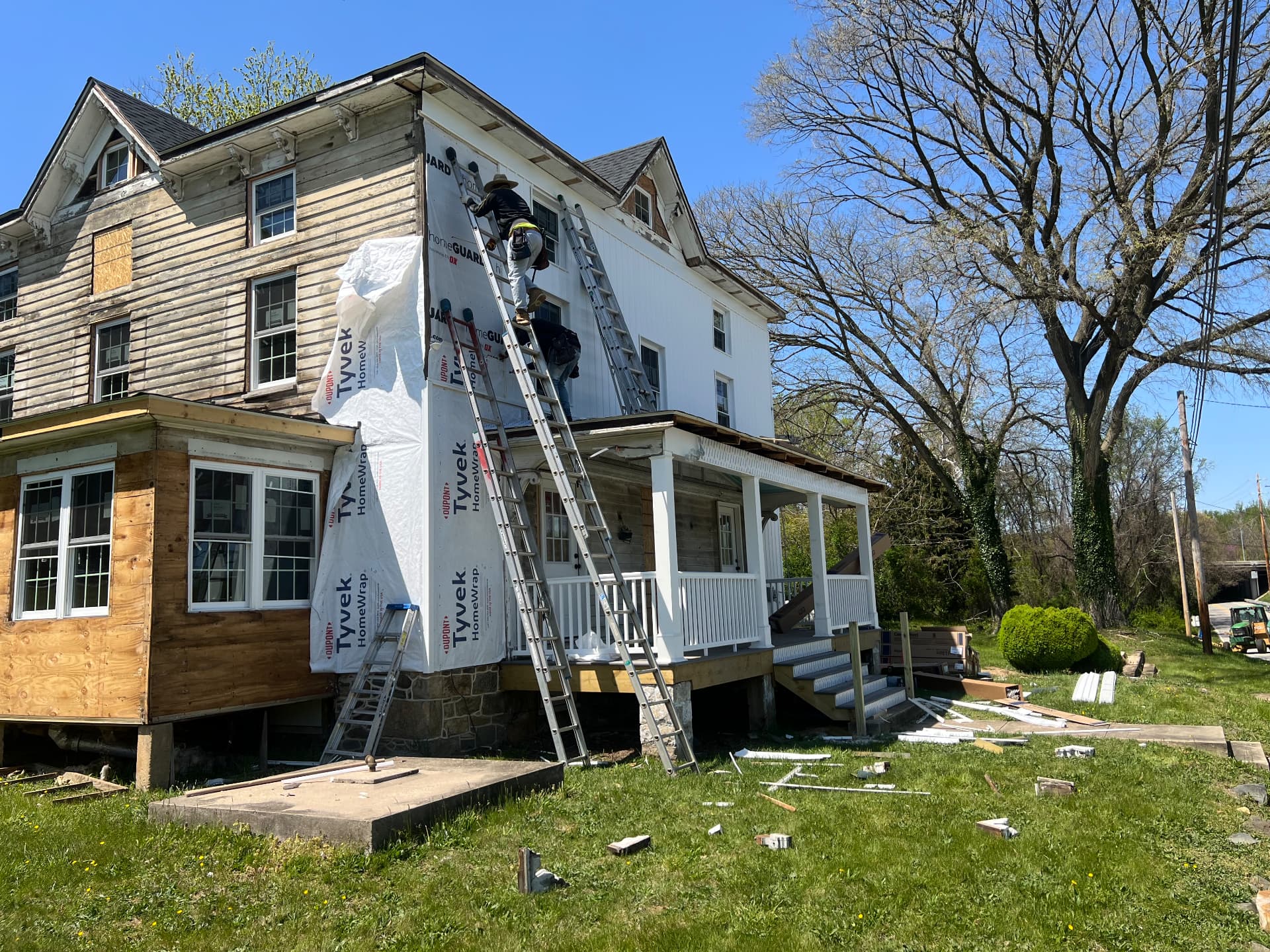 Siding going on over housewrap while the sunroom waits to be finished