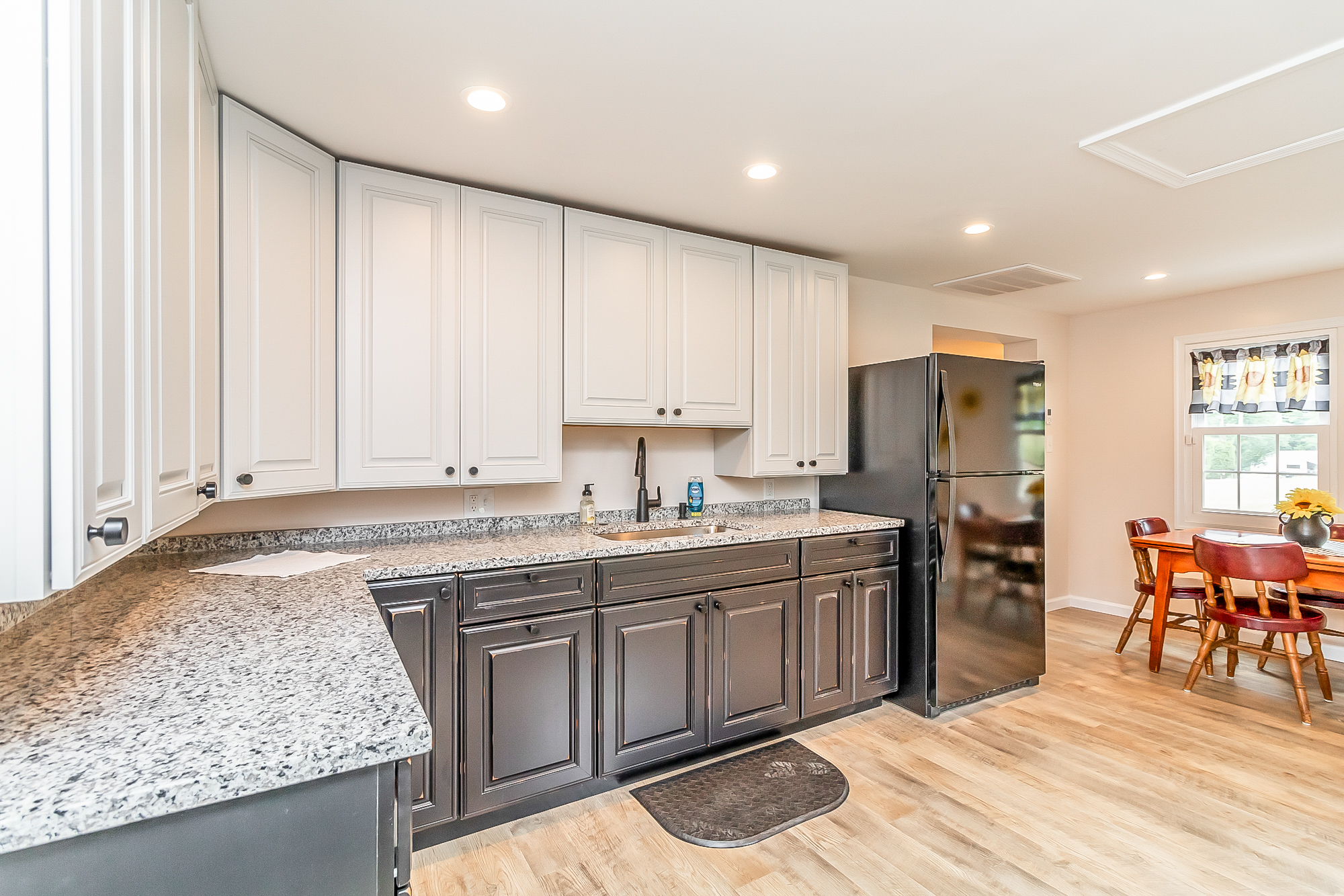 Granite counters and deep sink with the dining area beyond