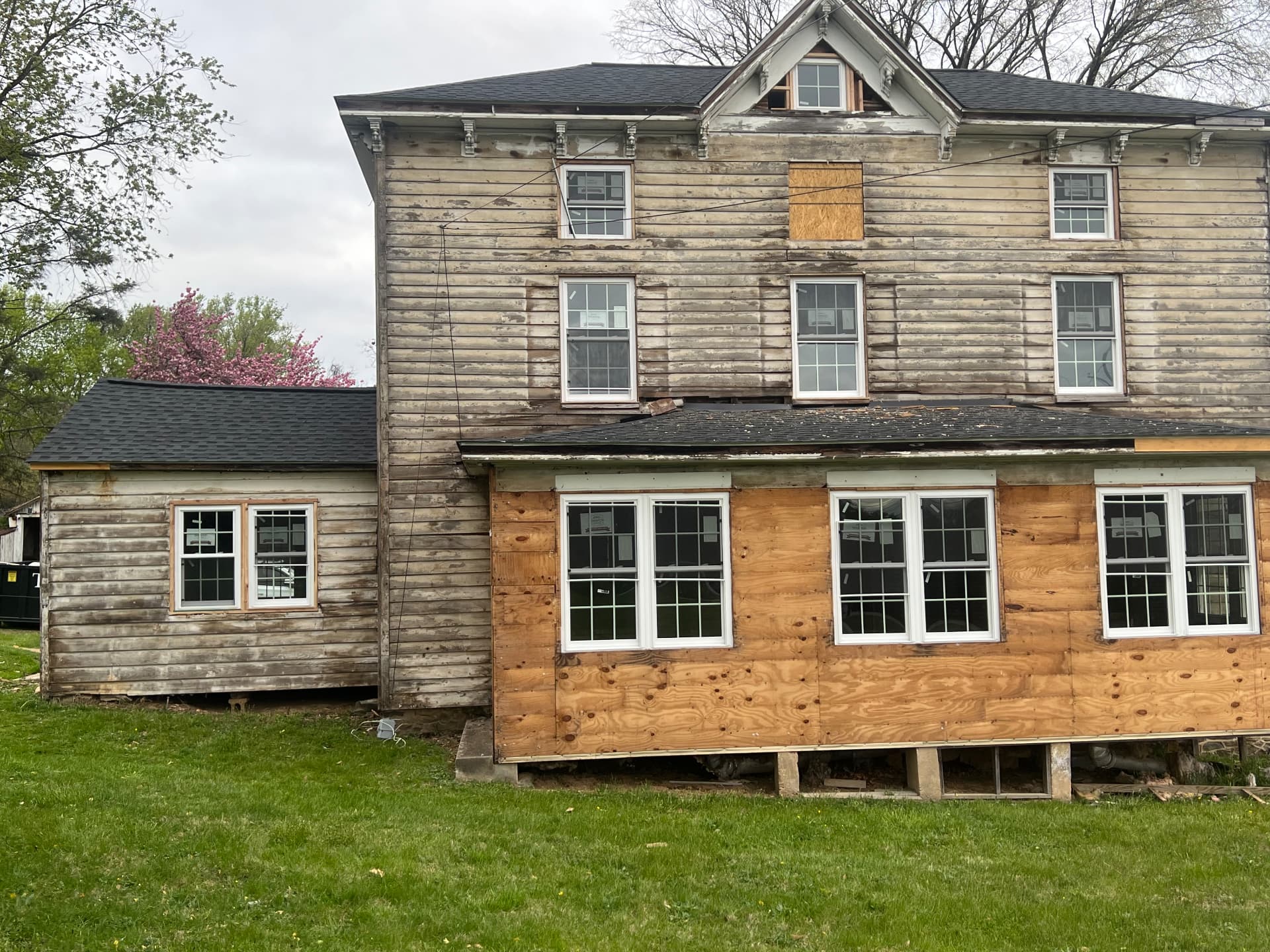 New windows set in fresh sheathing across the rear of the house