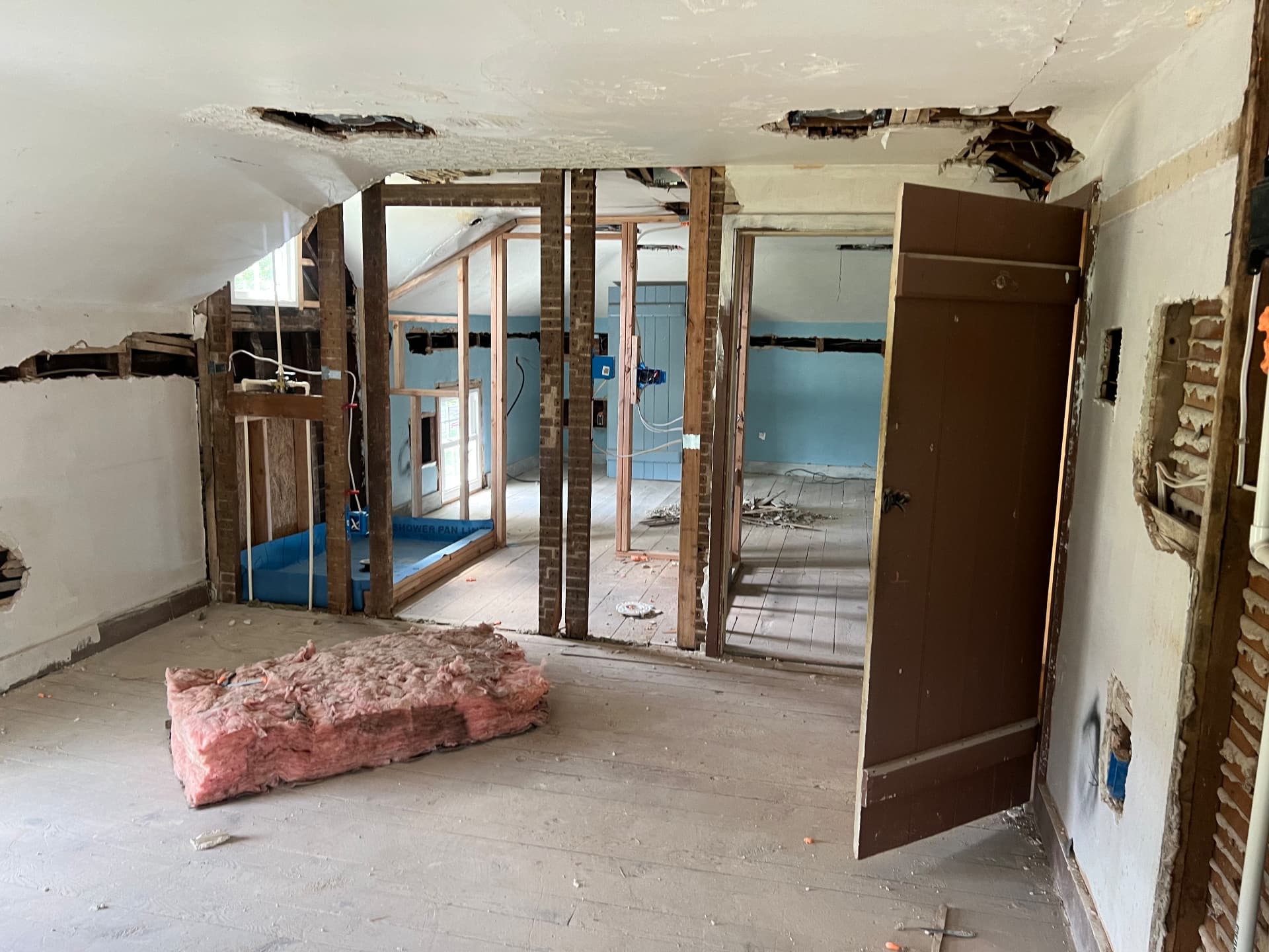 Upstairs bedroom opened to the original brick and timber with a new bath framed beyond