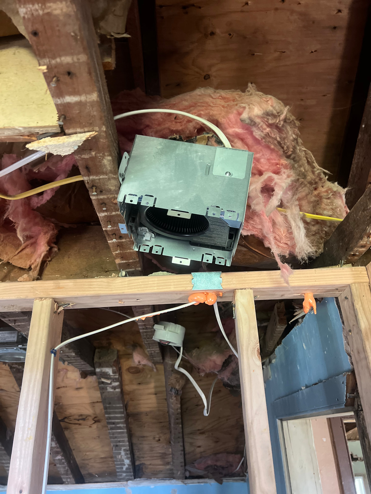 New wiring and recessed light fixtures set into the original ceiling joists