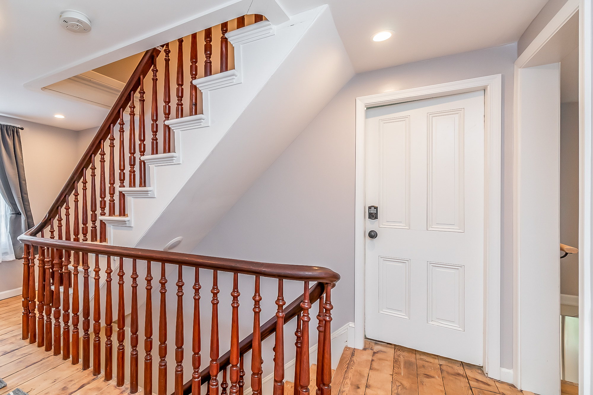 Upper landing with the restored walnut staircase and original pine floors