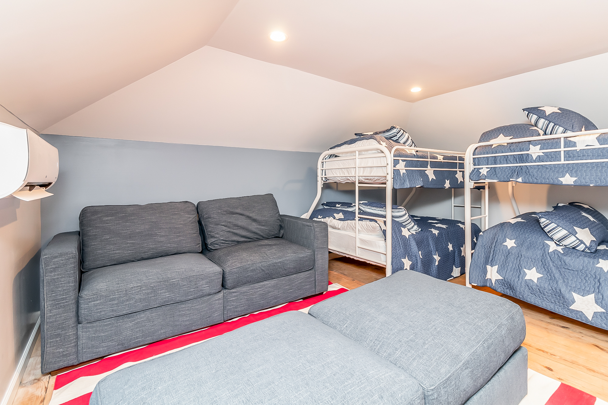 Bunk room with two sets of bunks, sofa and pine floors