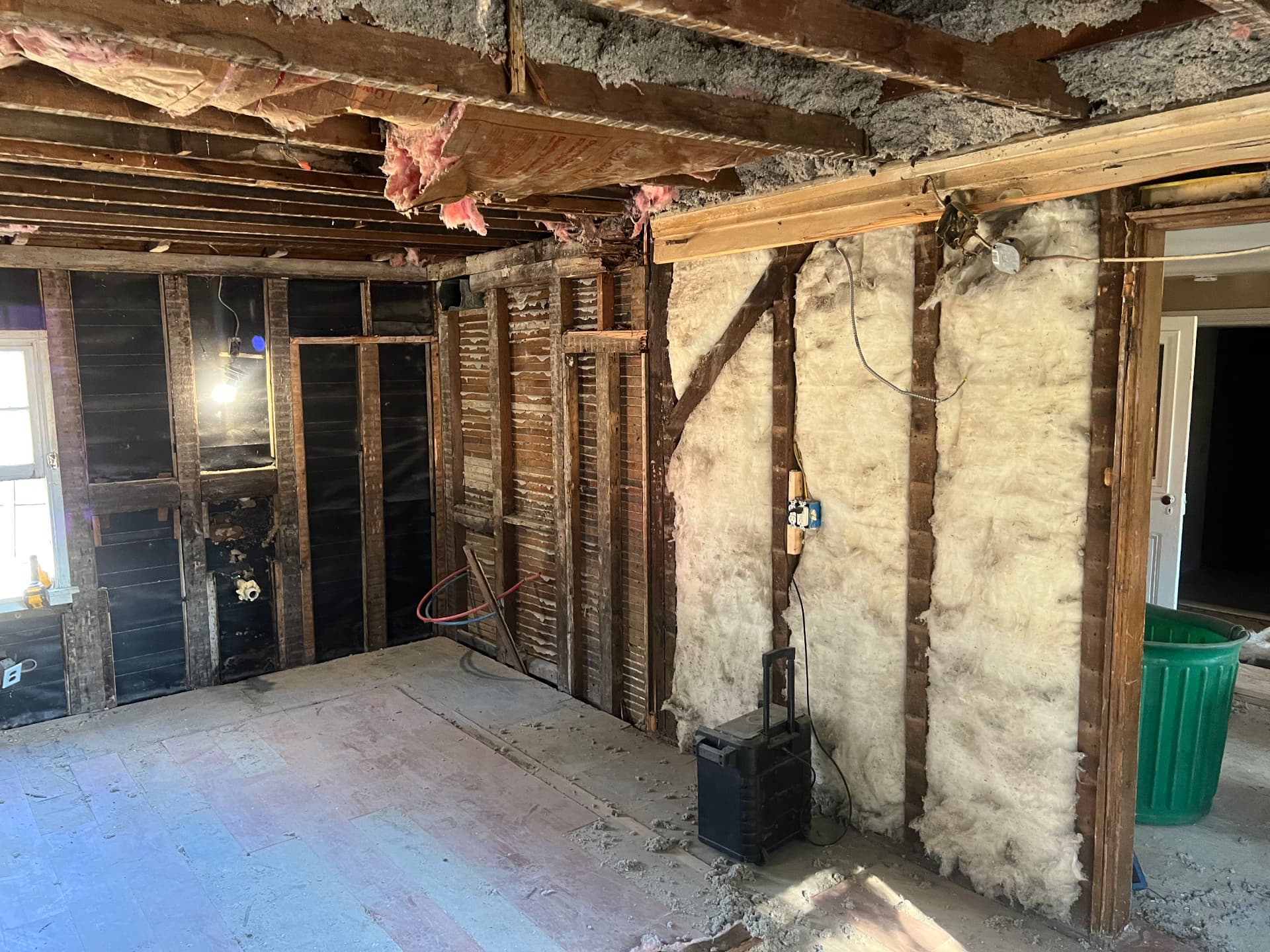 Original beadboard, lath and framing exposed through a rebuilt opening