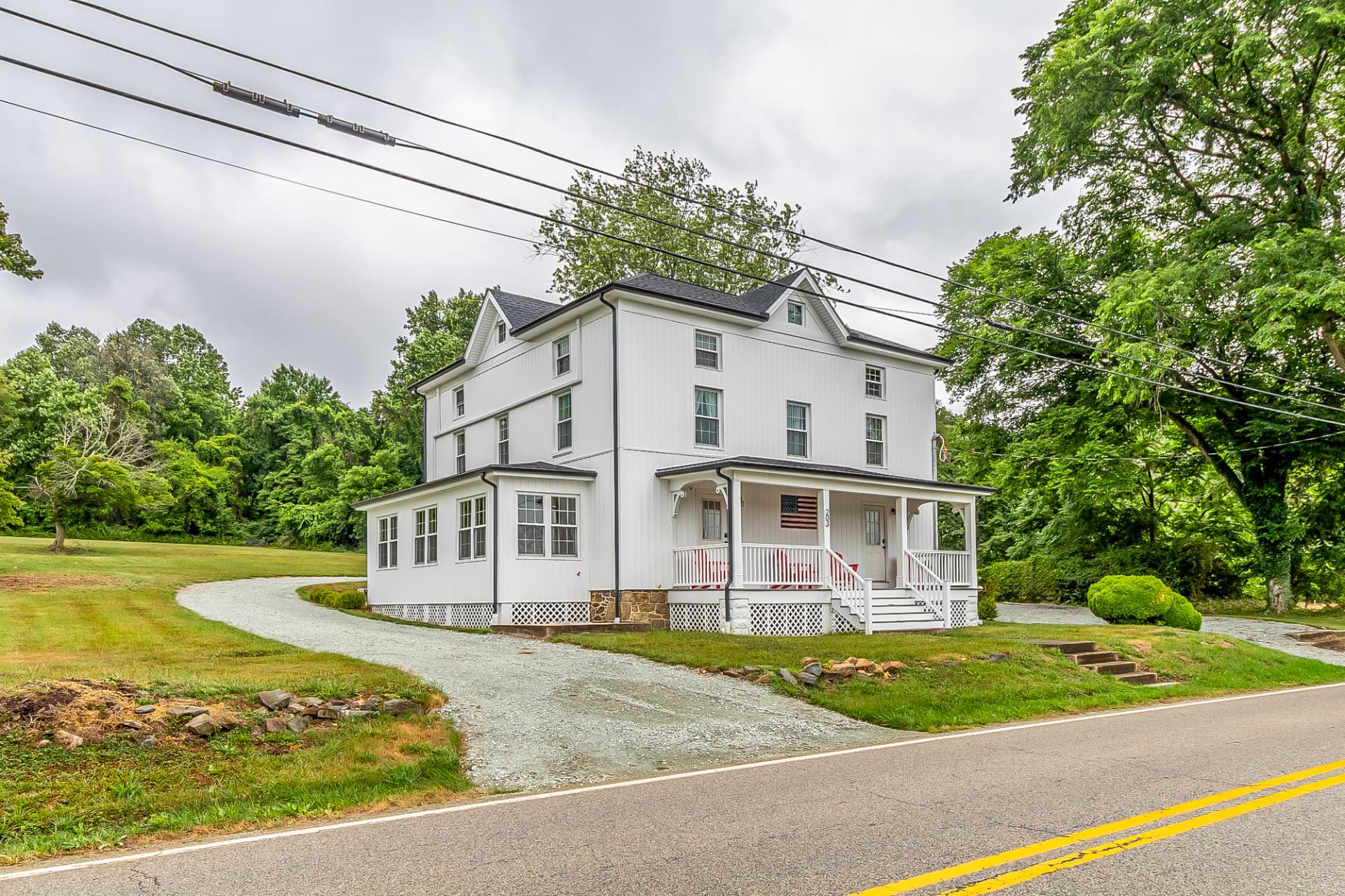 Side of the restored house showing the rebuilt sunroom and new gravel drive