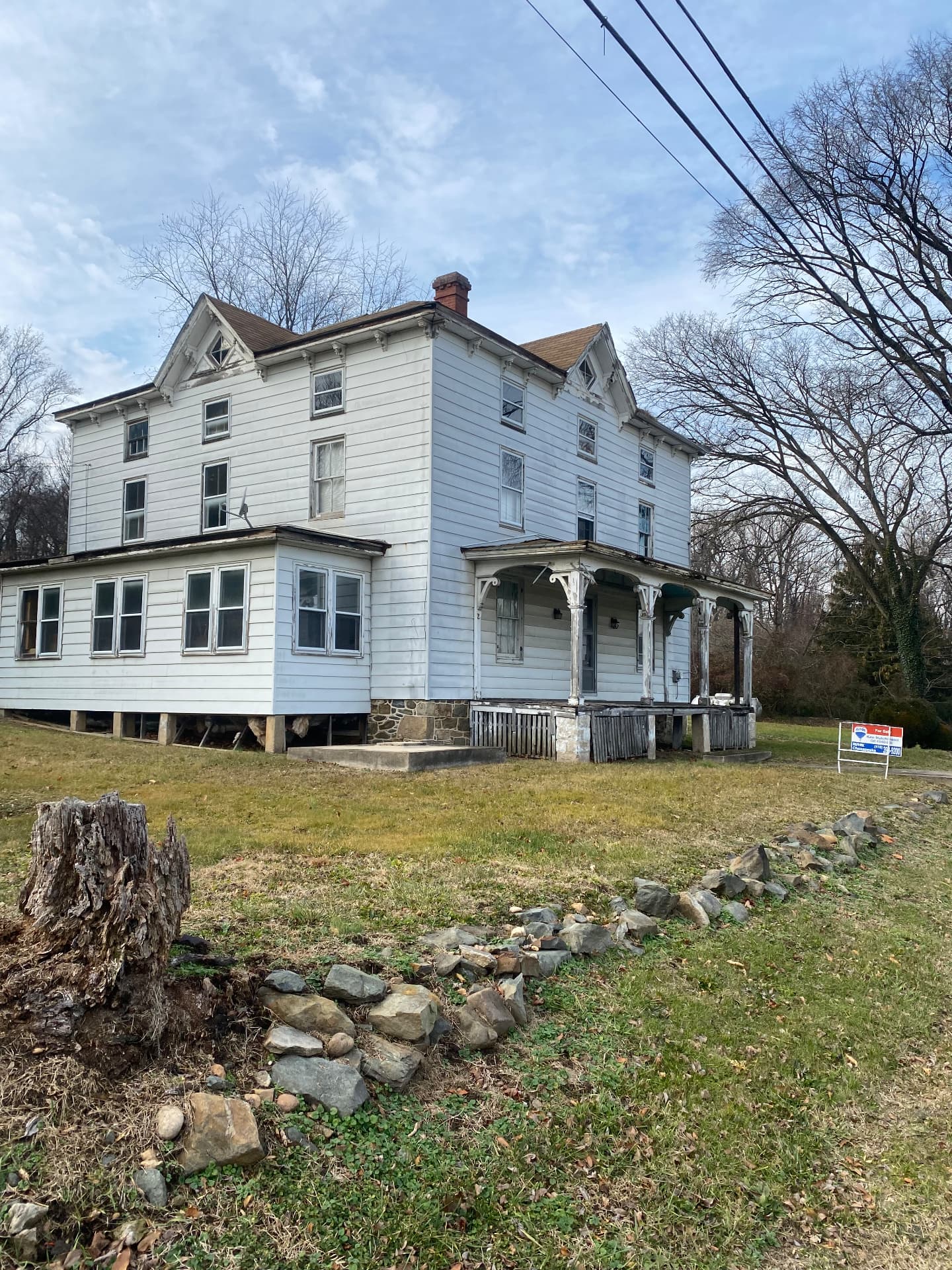 The 1870 farmhouse before restoration, vacant with a for sale sign in the yard