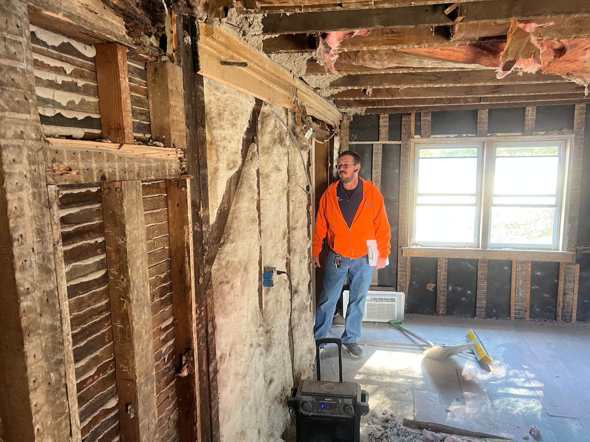 Crew member inspecting the original hand-split lath and timber frame
