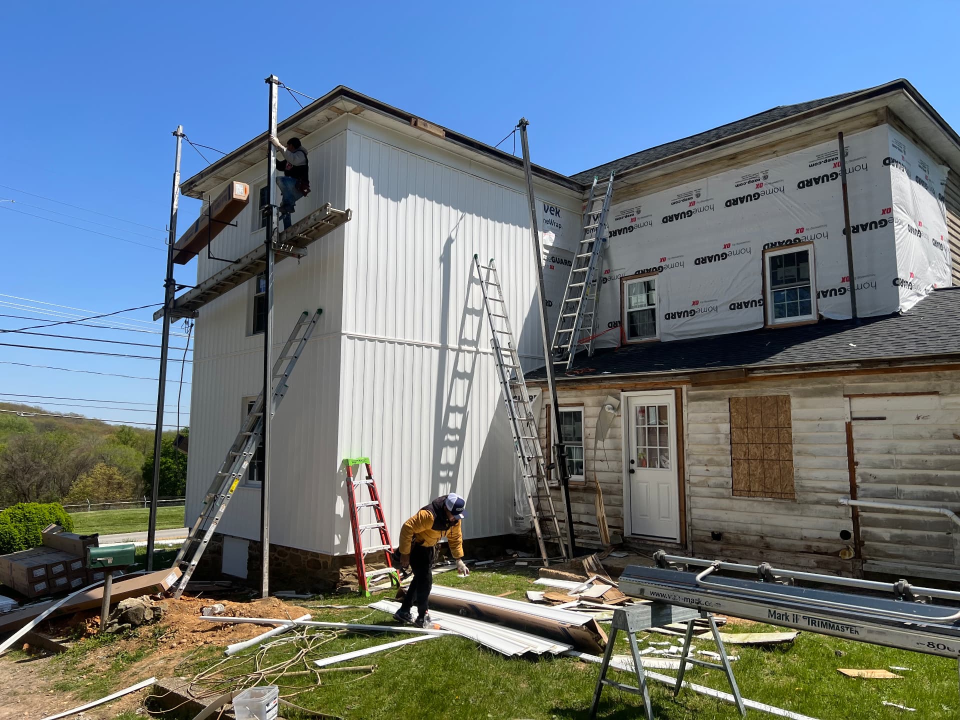 New siding going up the side while the rear addition is still wrapped in housewrap