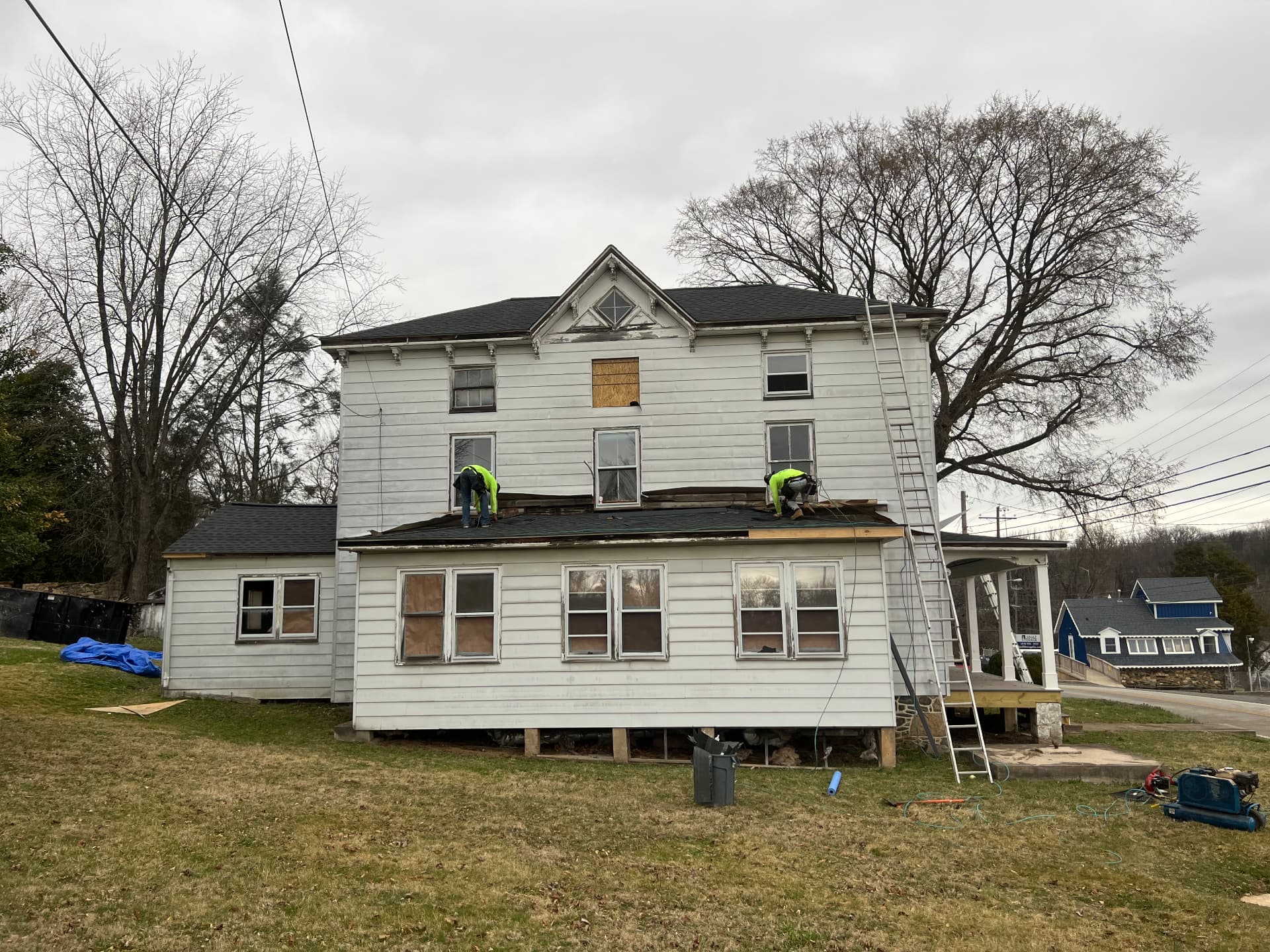 Roofers stripping and replacing the rear roof of the farmhouse