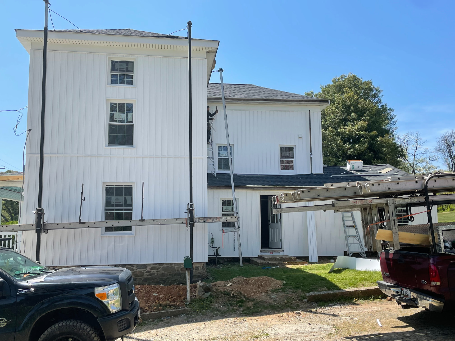 Crew finishing siding on the side of the house