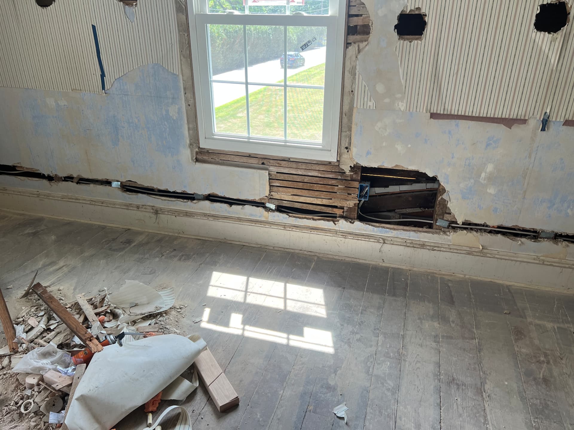 Original beadboard and layers of old paint revealed as walls are opened for new wiring