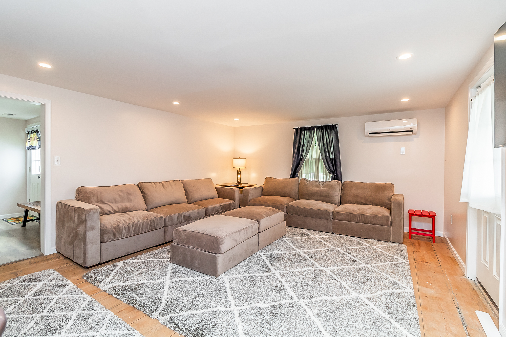 Wide view of the lounge with sectional seating and mini-split heating and cooling