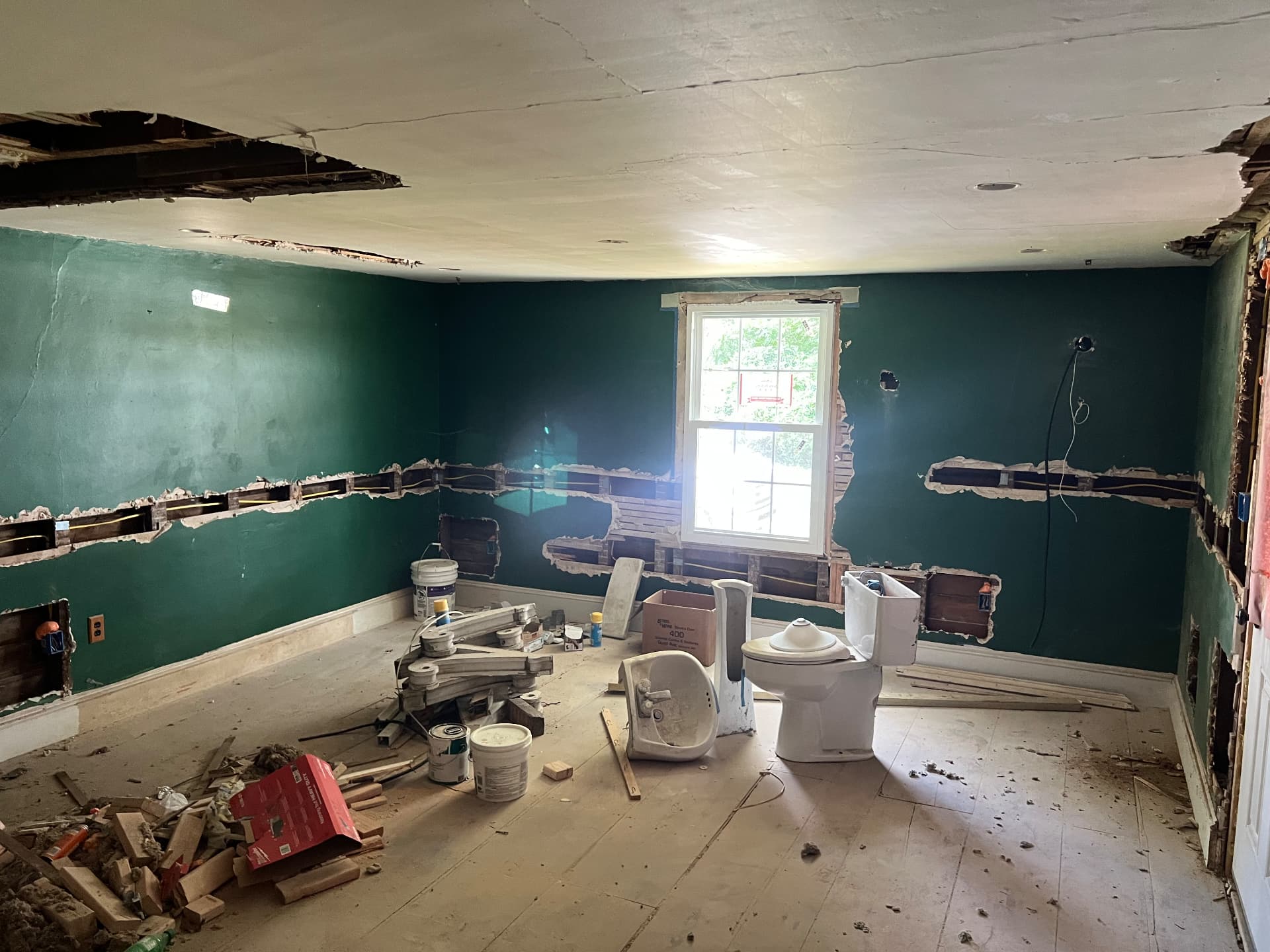 Old bathroom fixtures torn out and walls opened for new plumbing and wiring