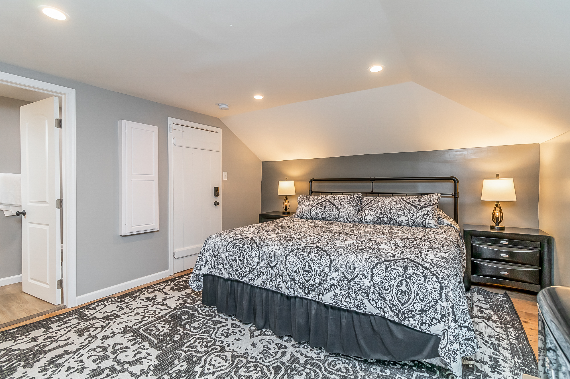King bedroom with iron bed and its own bathroom door