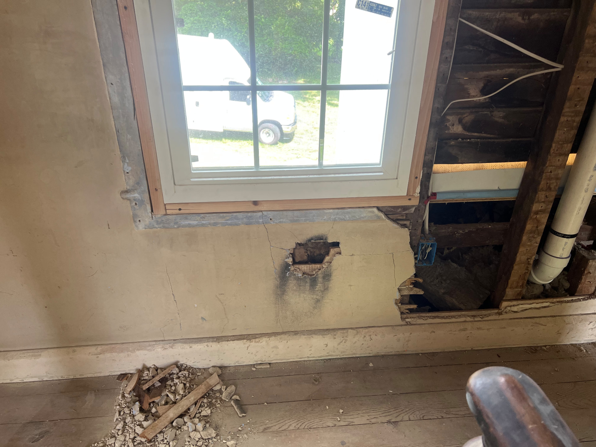 New window installed beside a wall opened to the original framing and new plumbing stack