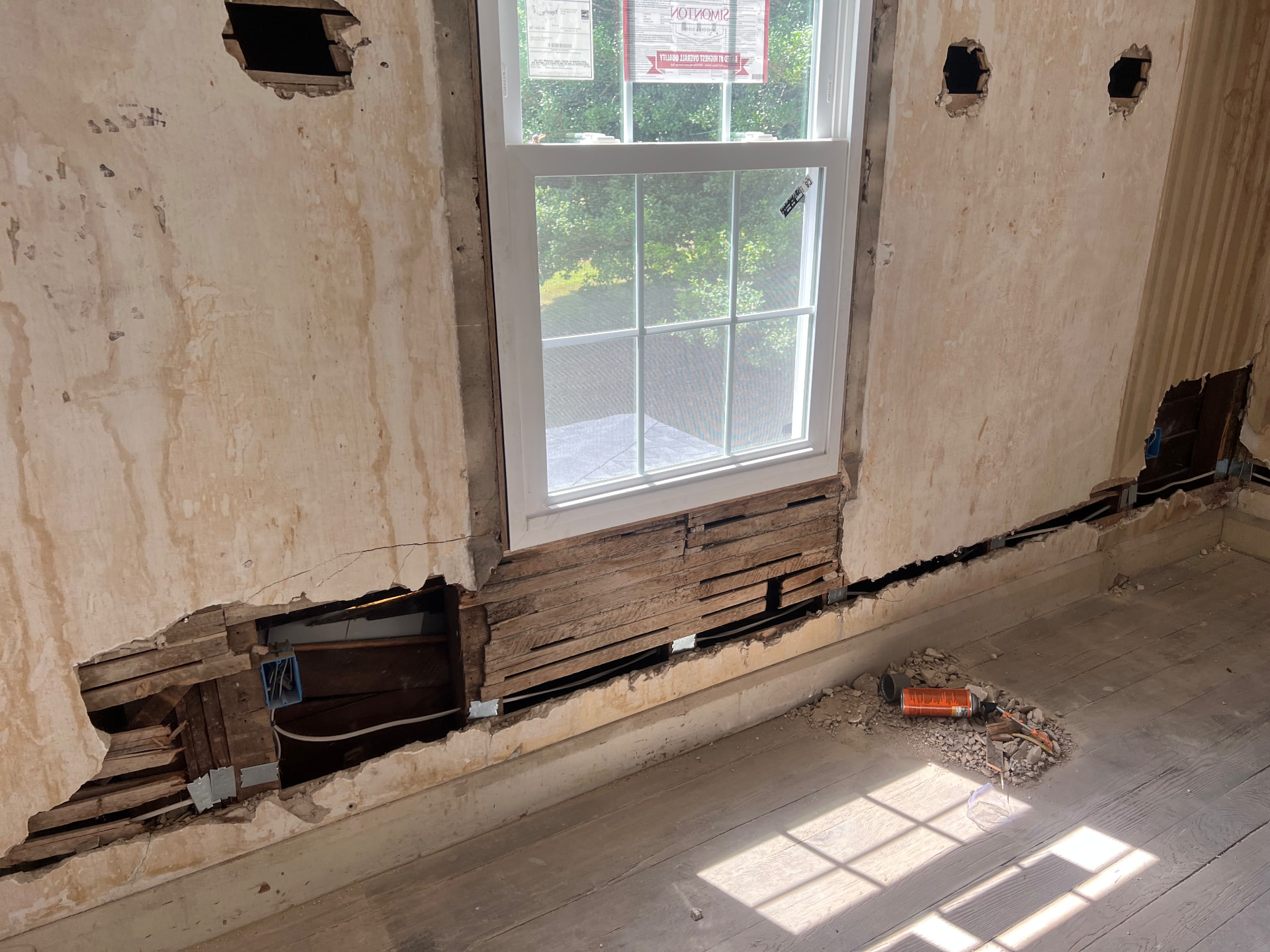 Original lath and plaster opened below a new window to run new wiring