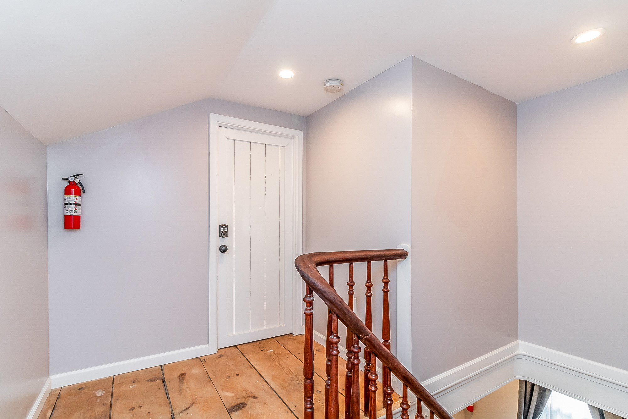 Top of the stairs with original pine floors and turned walnut railing
