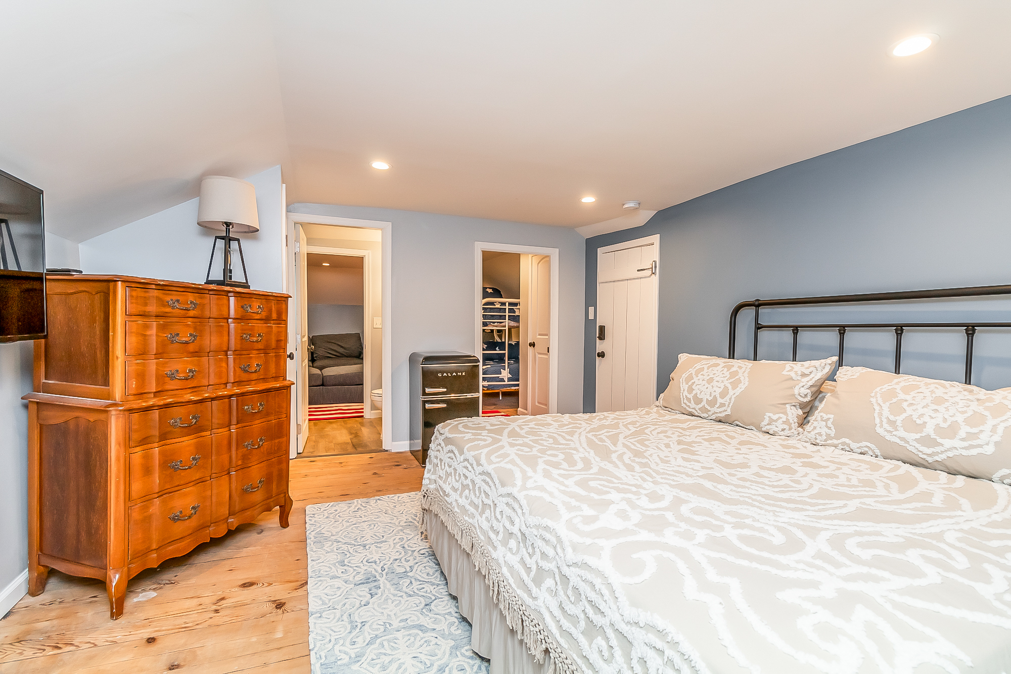 King bedroom with antique dresser and doorway to the bunk room