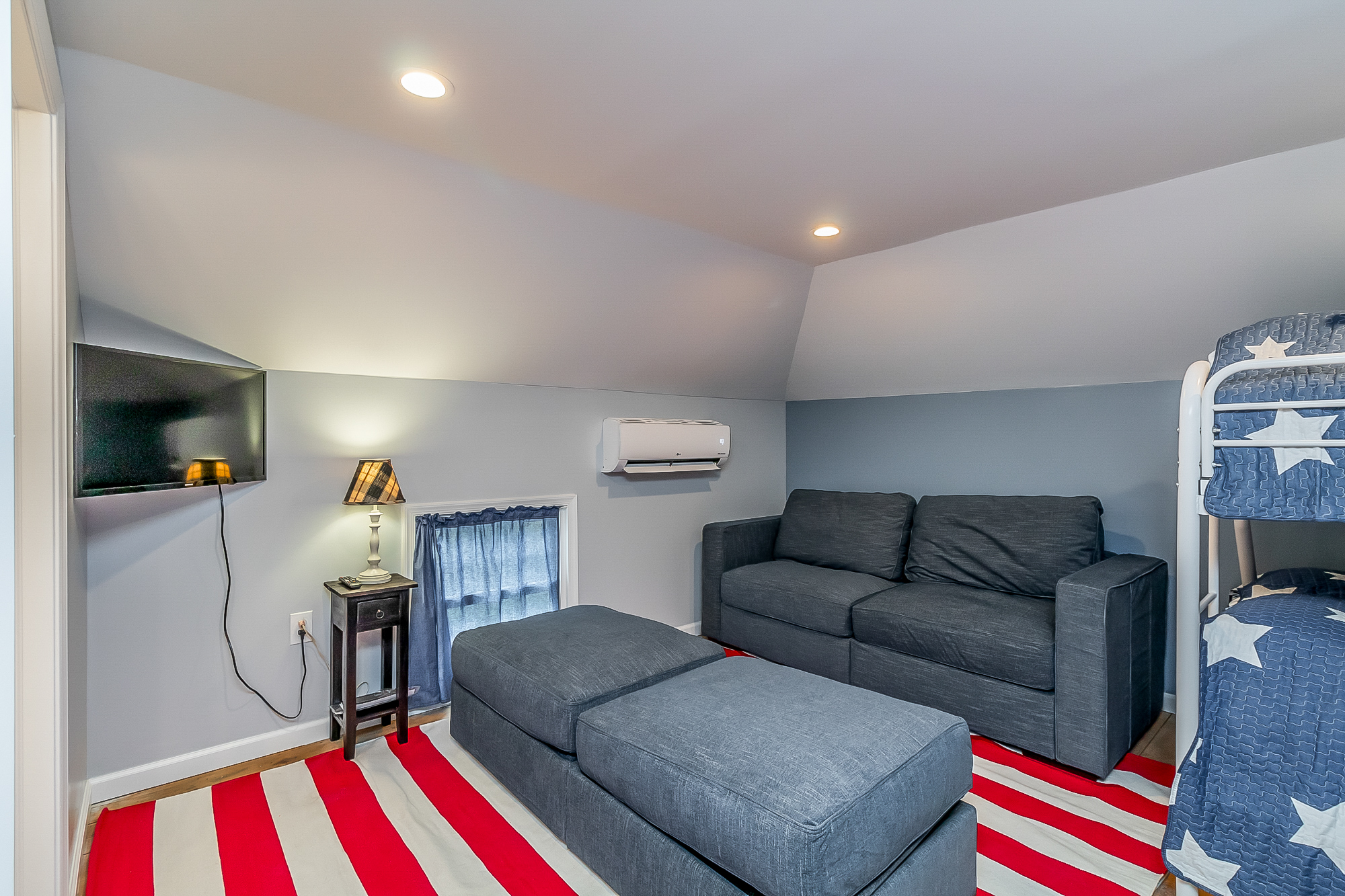 Bunk room lounge with TV, sofa bed and ottomans