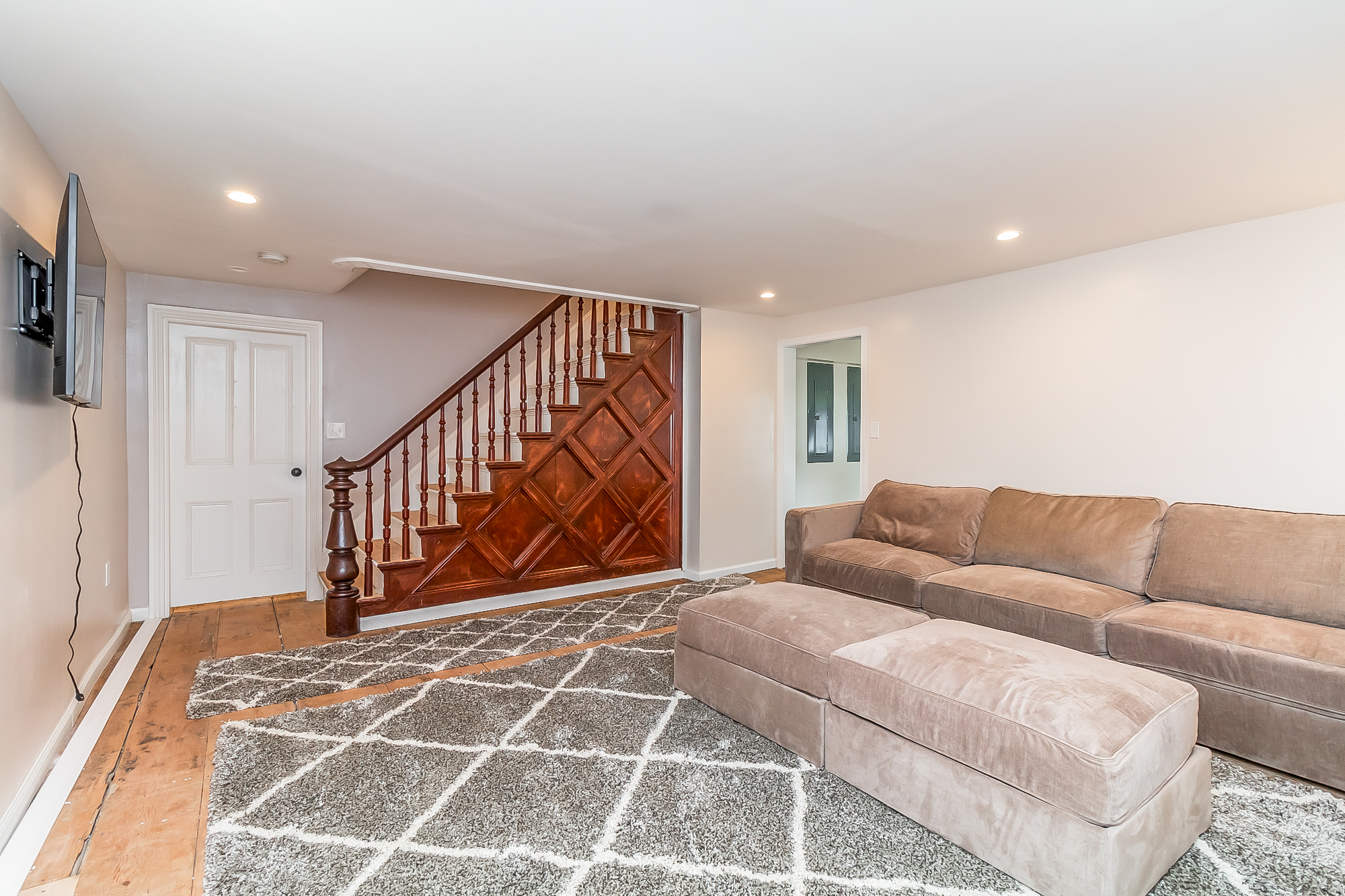 Restored staircase and banister beside the sectional lounge on original pine floors