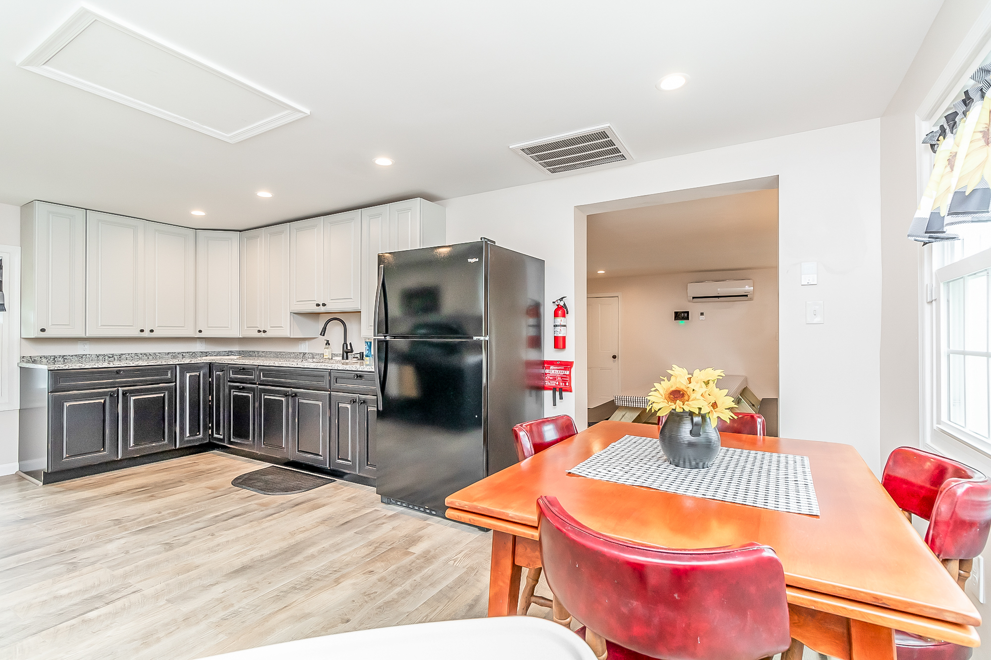 Kitchen opening to the dining table with red chairs