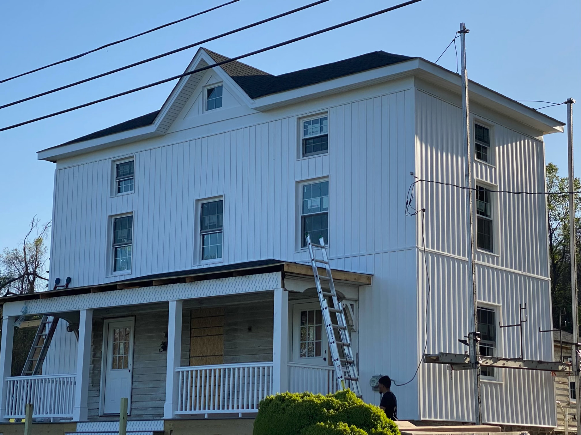 Crisp white board-and-batten siding finished across the upper floors