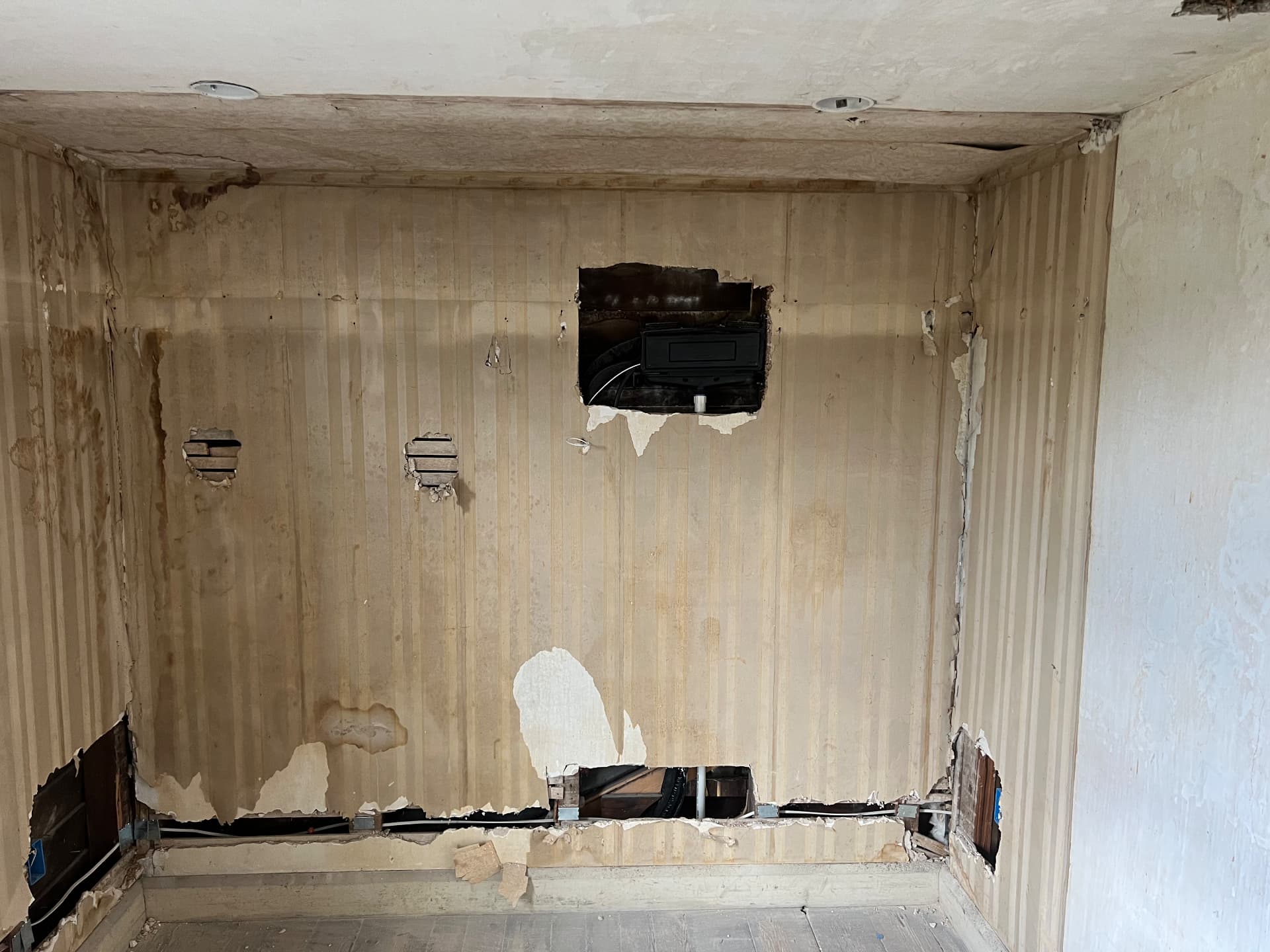 Water-stained original beadboard wall opened up for new wiring and plumbing