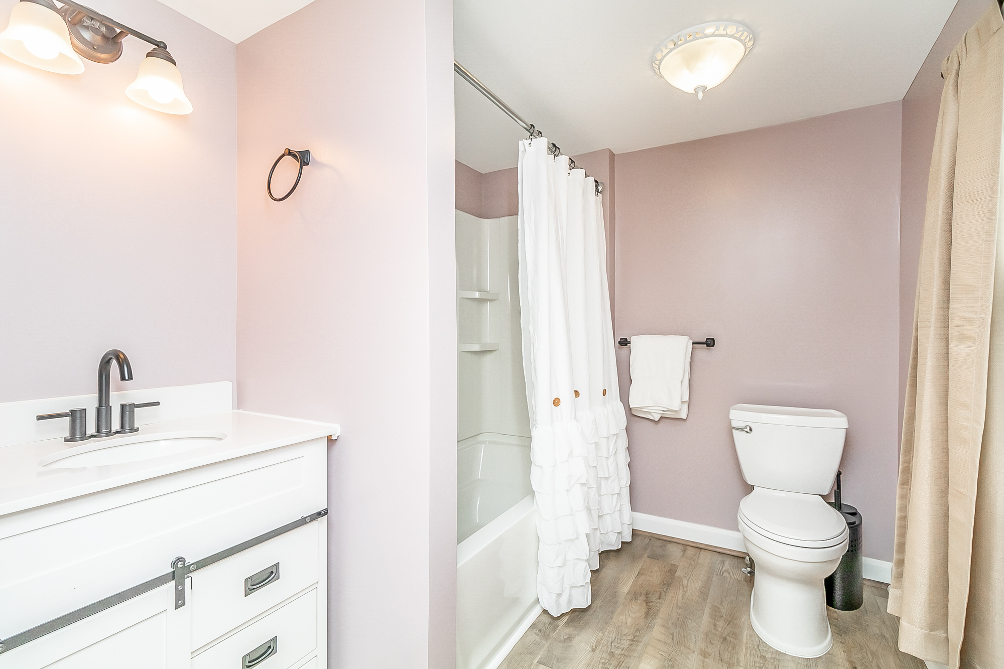 Lavender bath with white vanity, tub and shower