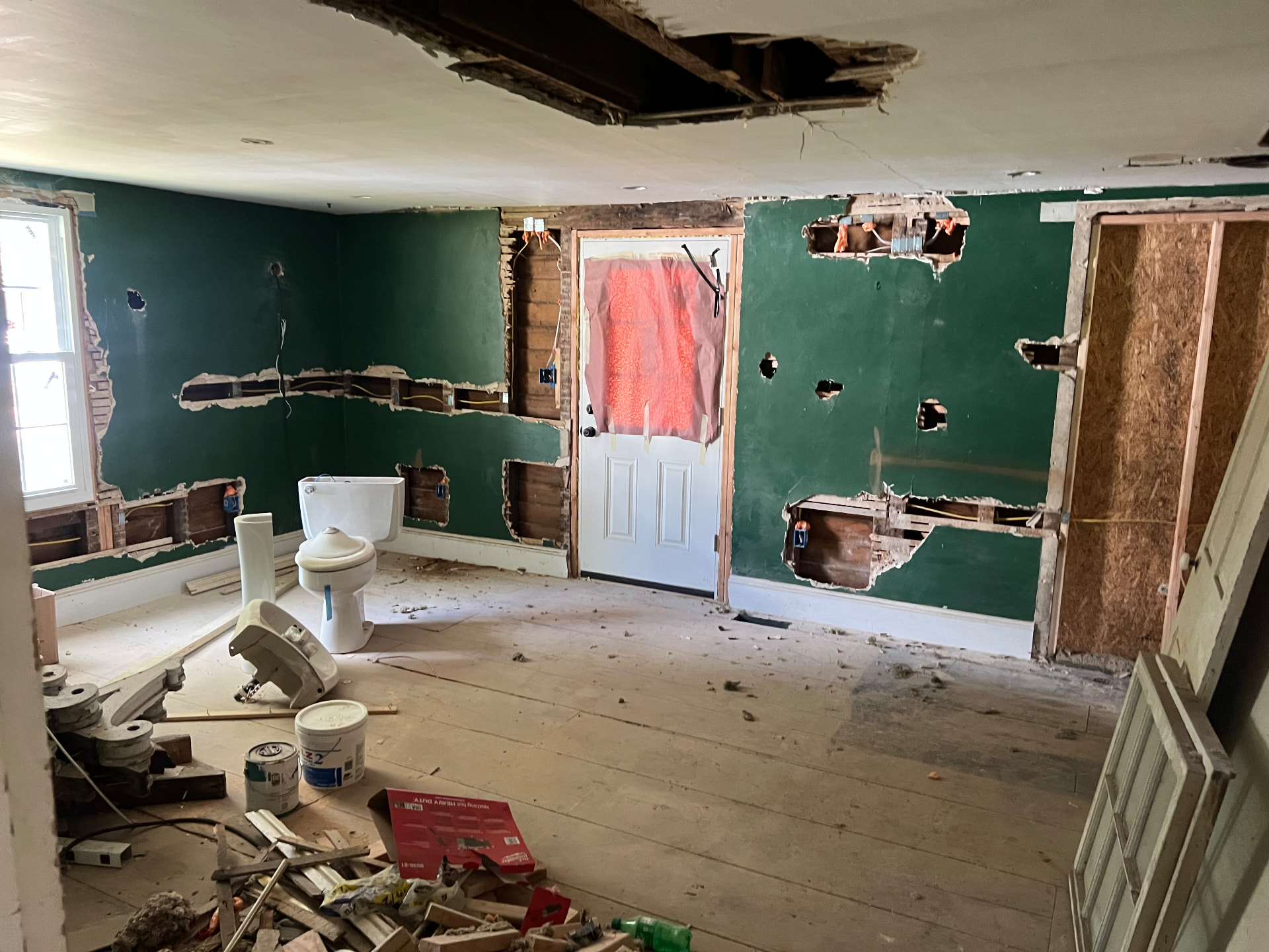 Old bathroom fixtures pulled out and walls opened for new plumbing and wiring