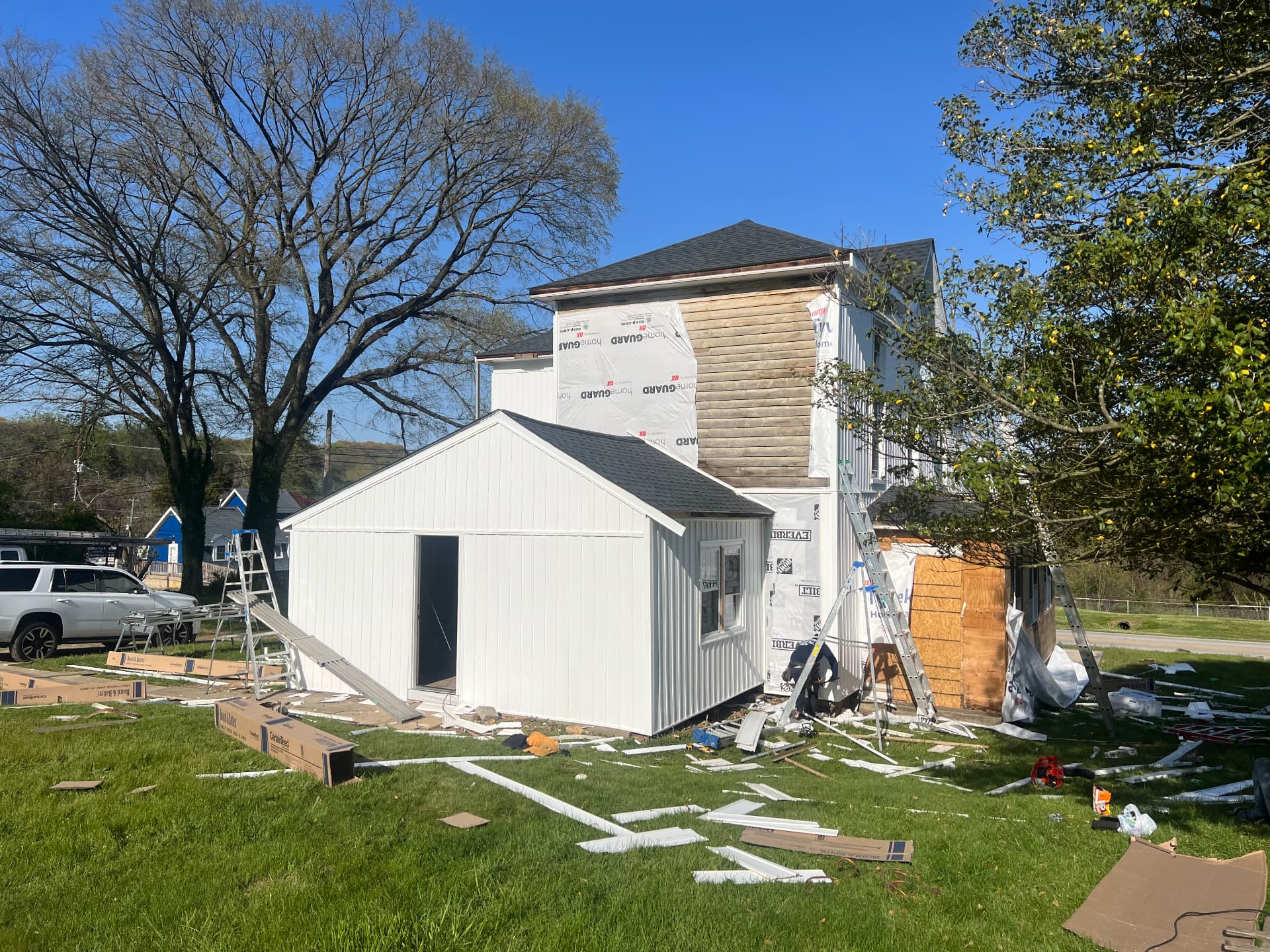 Rear addition finished in white board-and-batten siding with a new roof