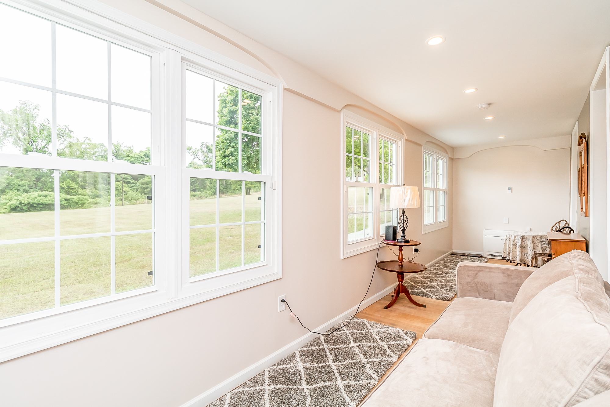Sunroom seating area with wide new windows looking onto the lawn