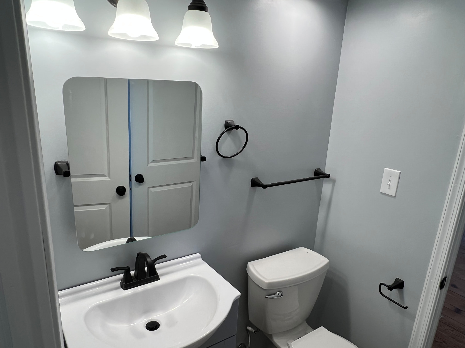 New bathroom with fresh vanity, mirror and matte black fixtures