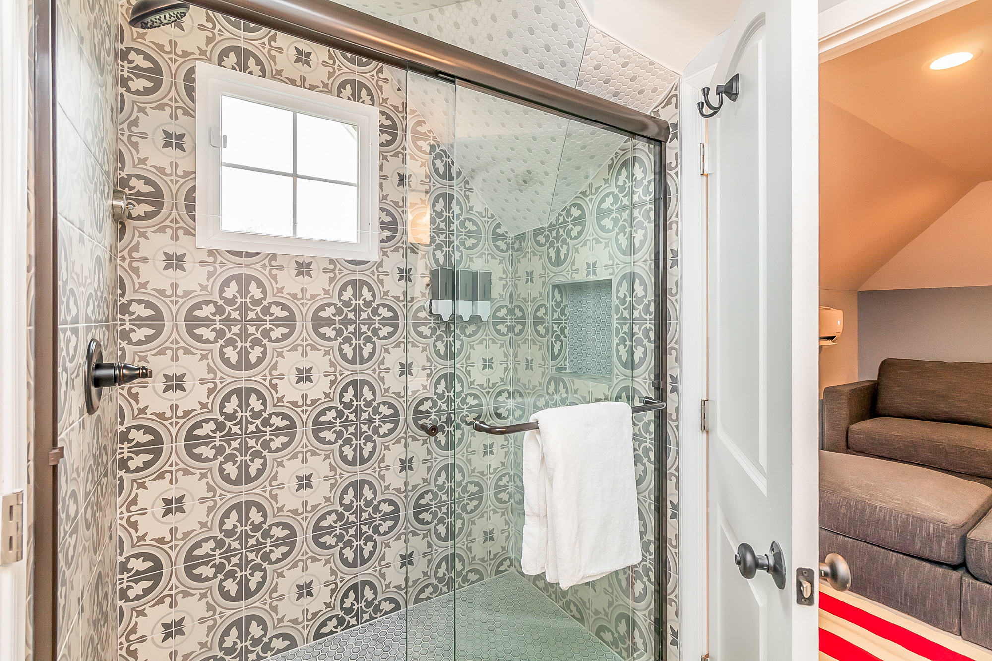 Tiled walk-in shower with patterned tile and glass door