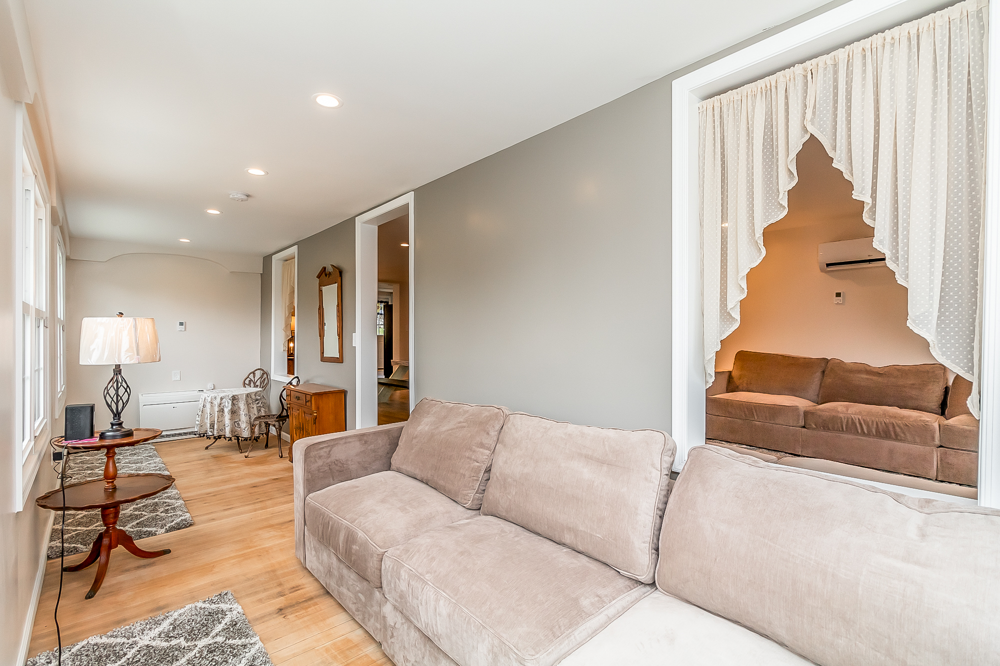 Sitting room with new hardwood floors, sofas and a game table
