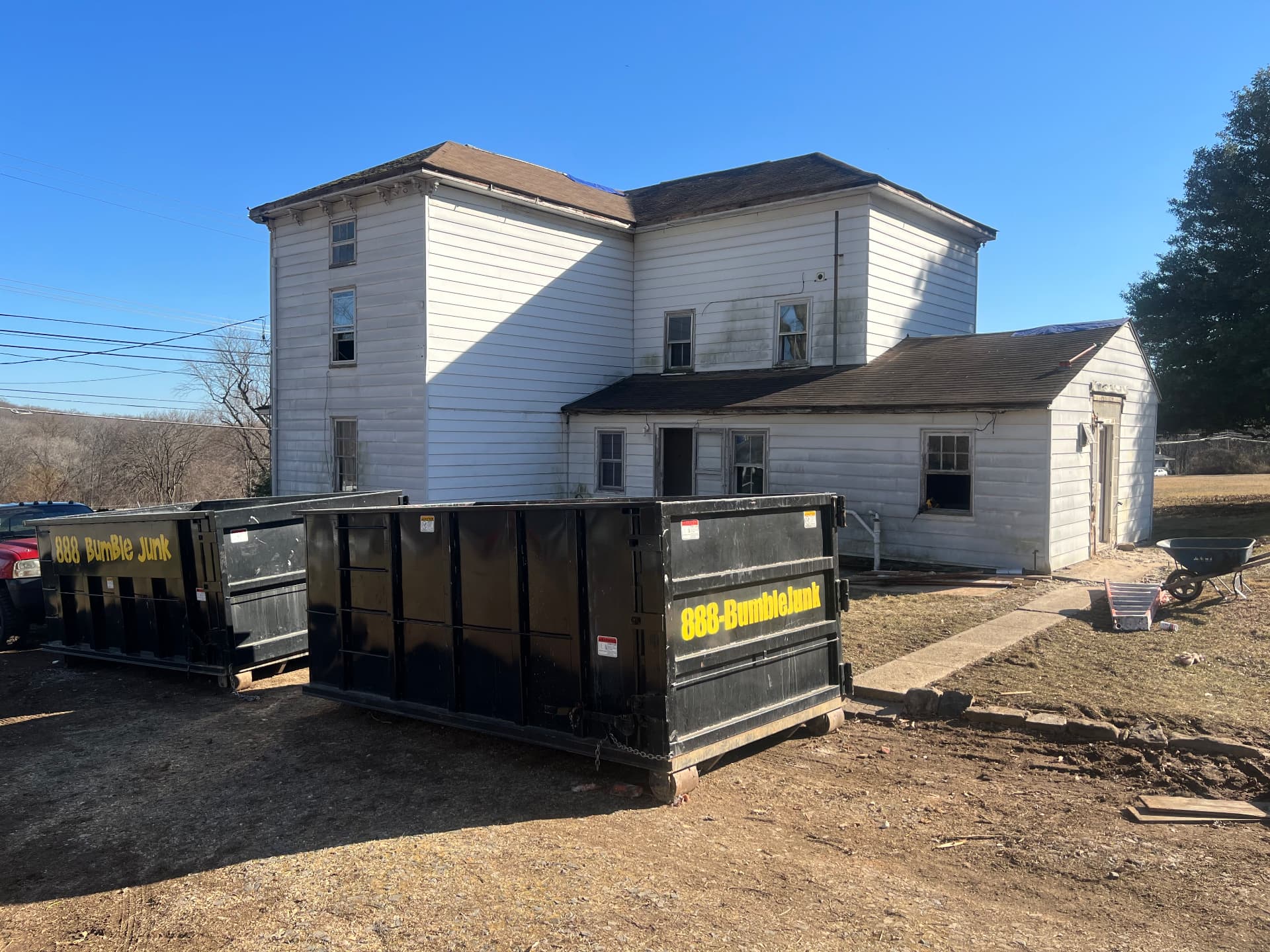 Dumpsters on site as the farmhouse and rear additions are gutted