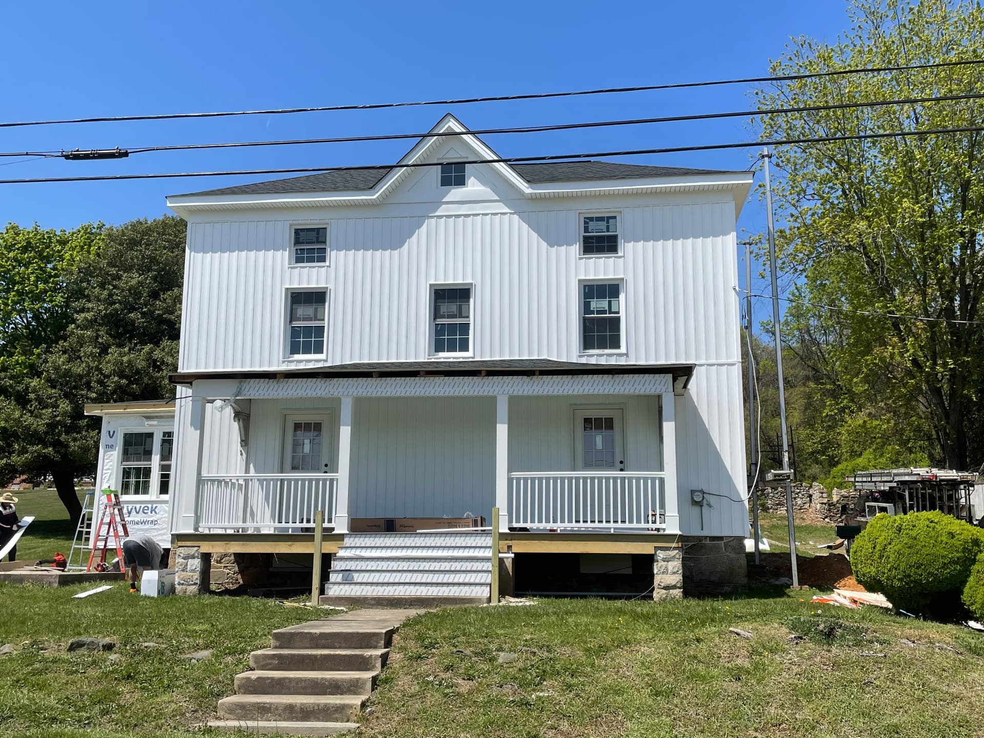 New board-and-batten siding and rebuilt front porch with railings