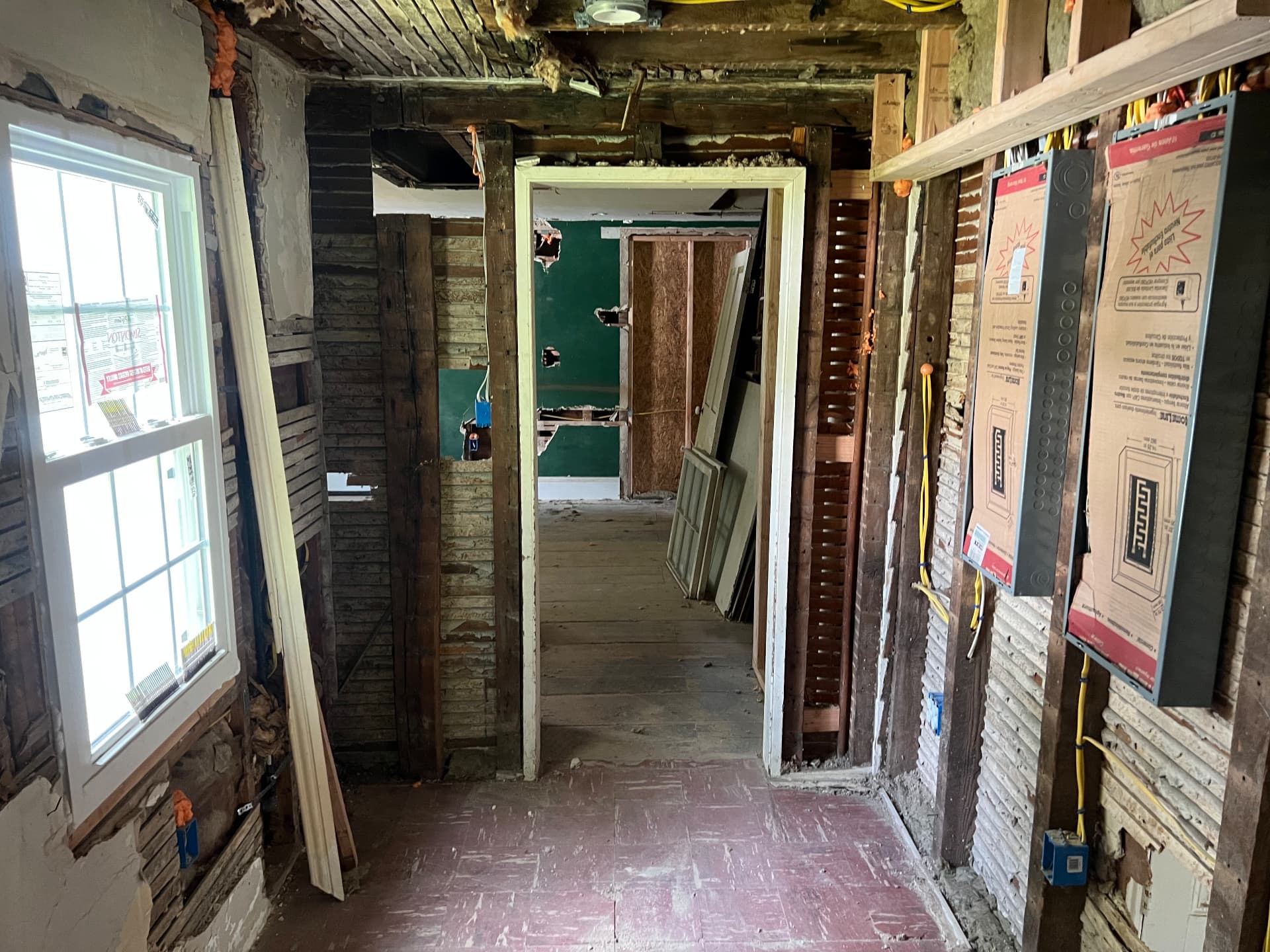 Hallway stripped to hand-split lath with original doors and trim saved to one side