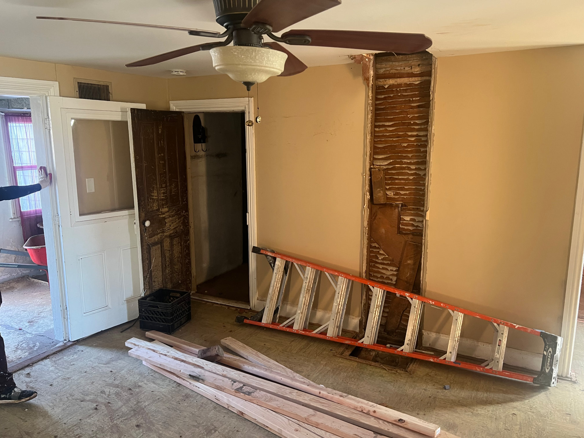 Interior wall opened to reveal original lath beside a salvaged door