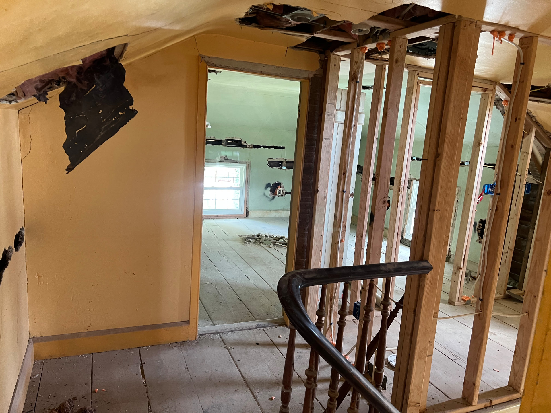 Upstairs landing with new framing going in beside the original banister