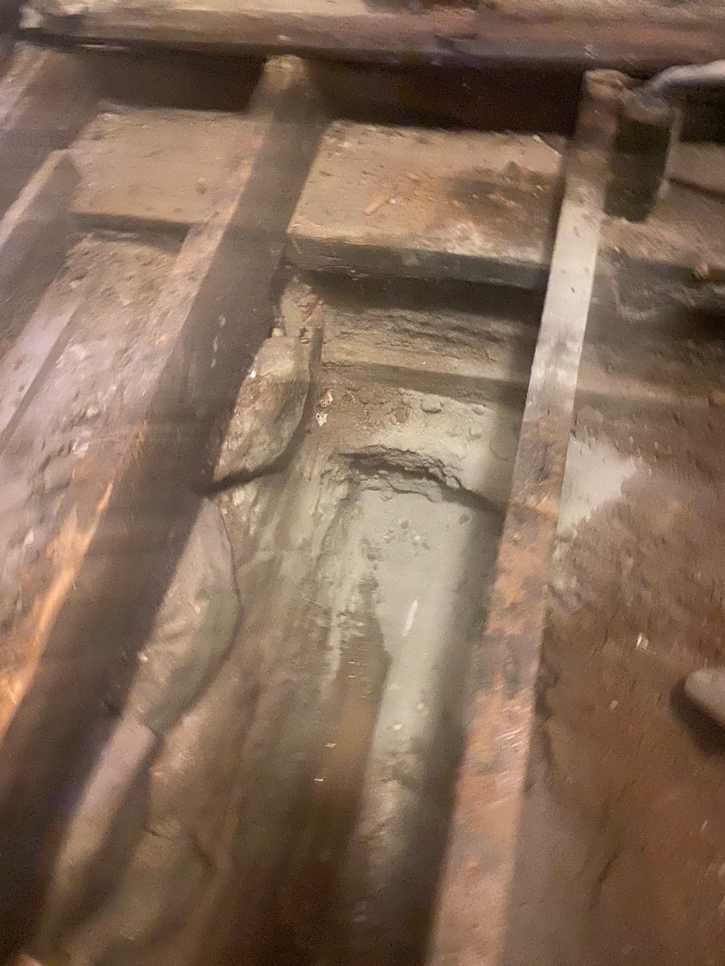 New plumbing lines run beneath the original hand-hewn floor joists