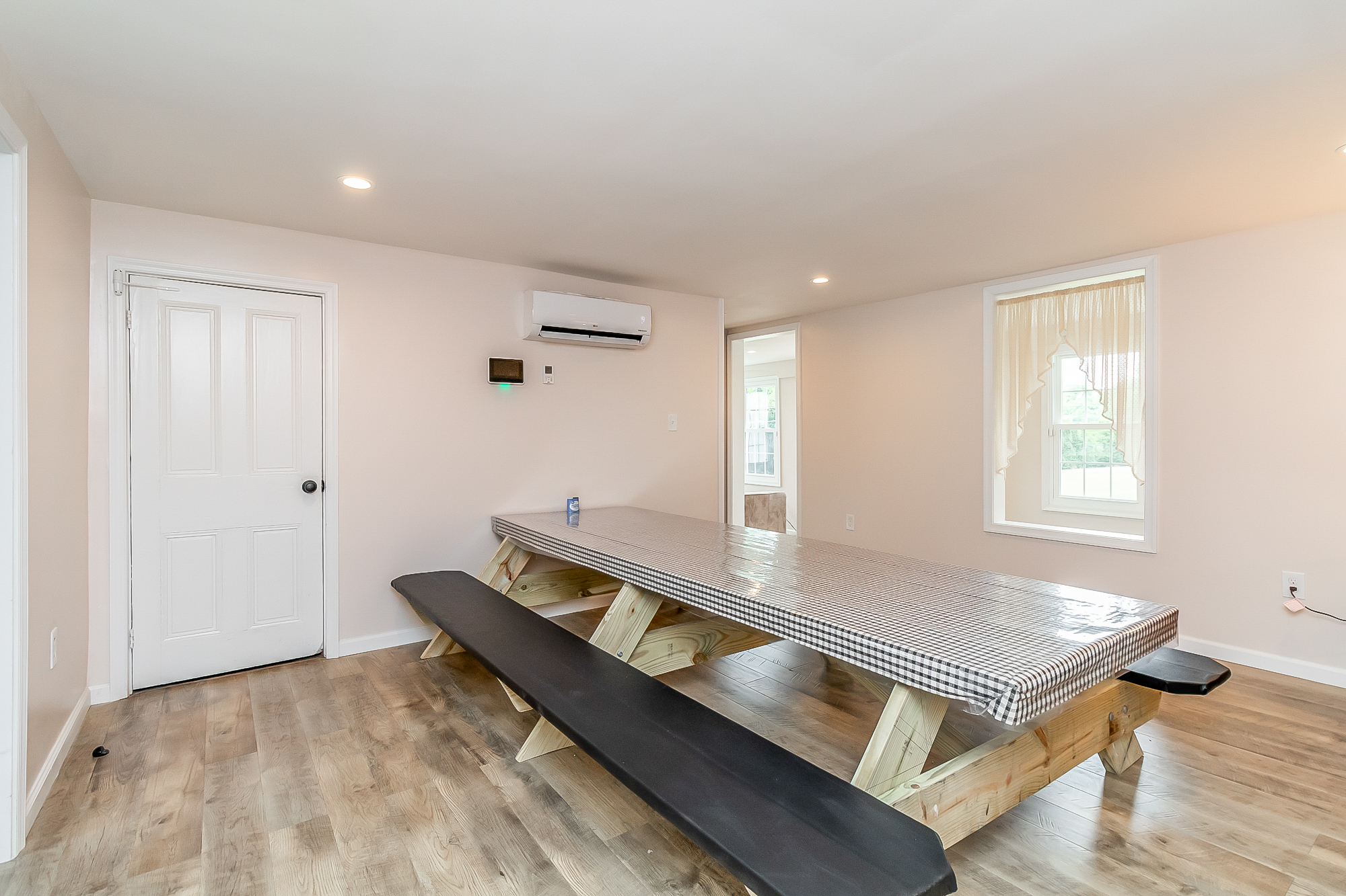Gathering room with the long table, new flooring and country window views