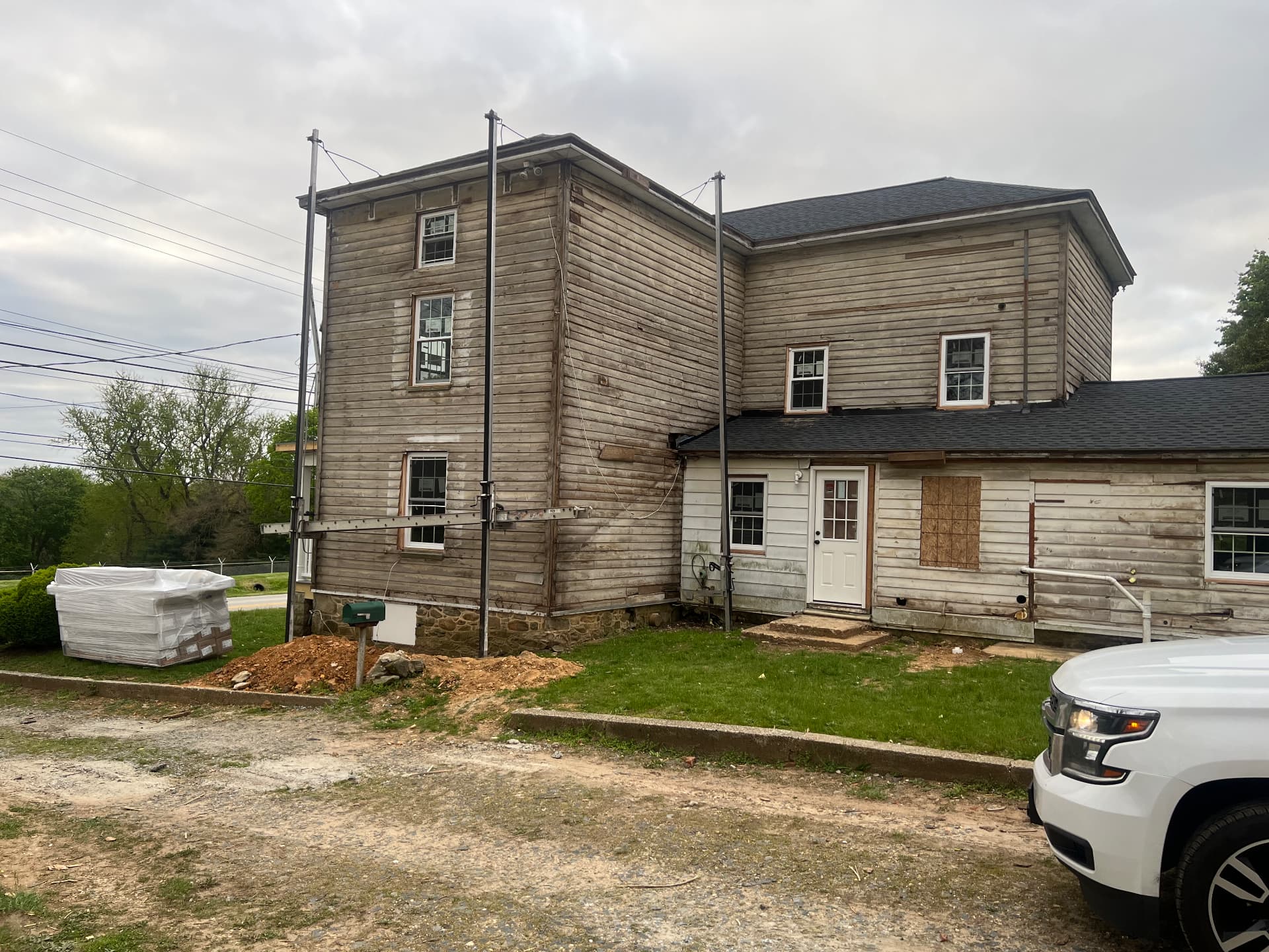Original siding stripped back to bare wood along the side of the house